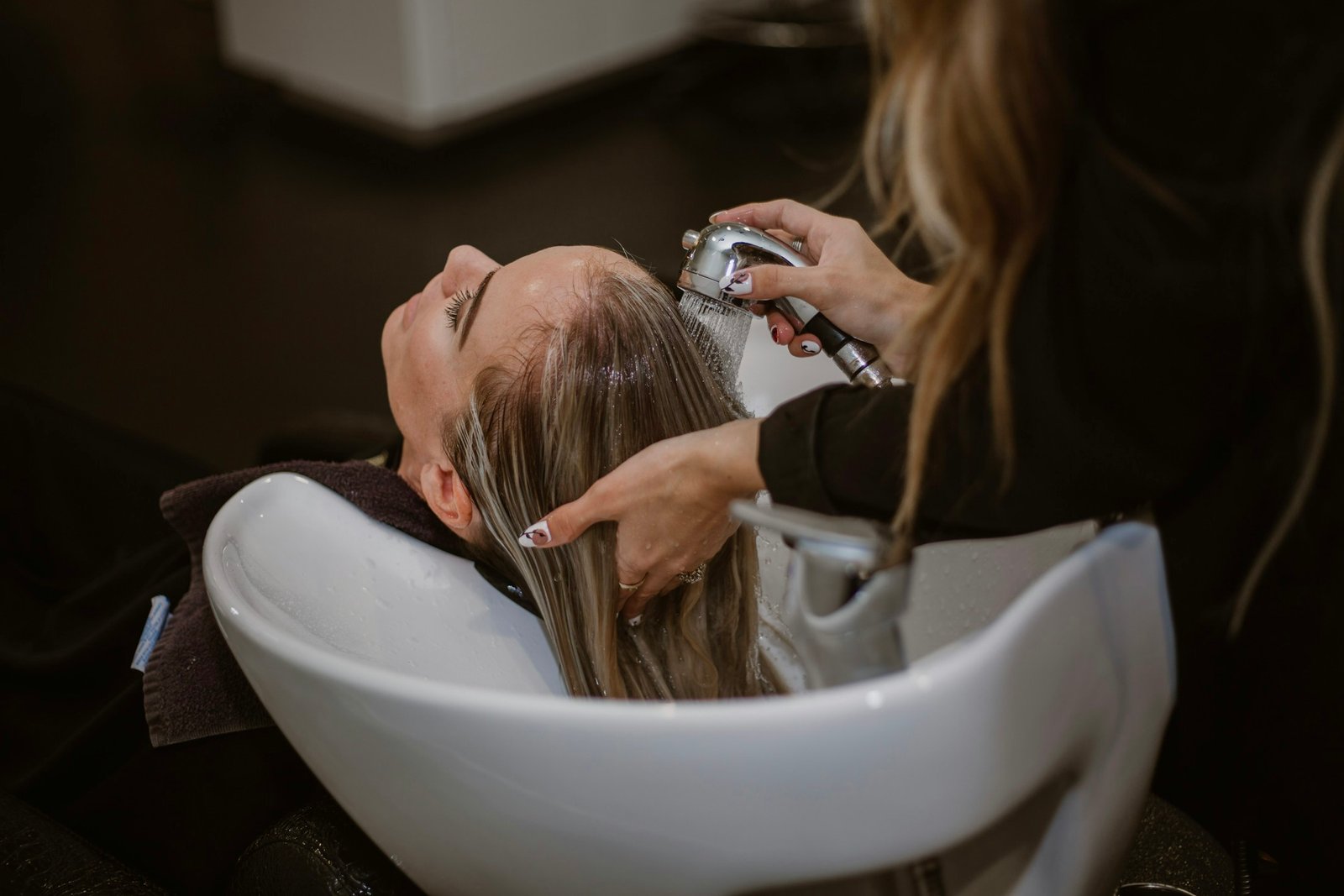 Profissional realizando tratamento capilar em salão de beleza